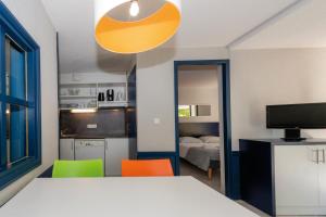 a room with a bed and two chairs and a kitchen at Residence Vacances Bleues Lou Castel in Casteljau