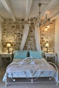 a bedroom with a bed with a stone wall at Petite Olive House in Sitia