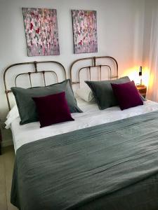 1 dormitorio con 1 cama grande con almohadas rojas y verdes en Topacio Tower Apartamento Nara I en Buenos Aires