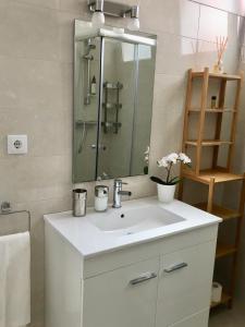een badkamer met een witte wastafel en een spiegel bij Feel Cascais Center 2bd in Cascais