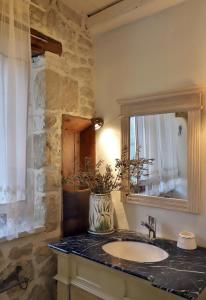 a bathroom with a sink and a mirror at Petite Olive House in Sitia