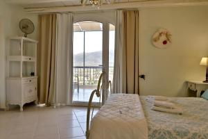 a bedroom with a bed and a door to a balcony at Petite Olive House in Sitia
