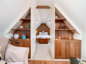 a attic room with a bed and a staircase at Pass the Keys Tranquil Chilterns Farm Hideaway in Little Missenden