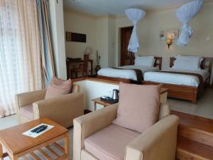 Habitación de hotel con 2 camas y sala de estar. en Great Rift Valley Lodge and Golf Resort en Naivasha