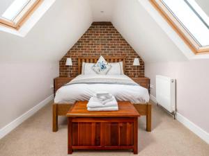 a attic bedroom with a bed and a table at Pass the Keys Tranquil Chilterns Farm Hideaway in Little Missenden