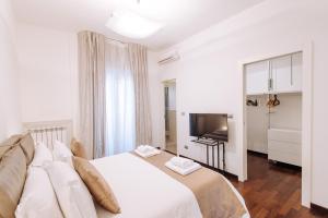 um quarto com uma cama branca e uma televisão em Piccinni Exclusive Suite em Bari
