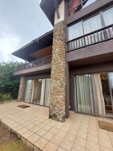 Great Rift Valley Lodge and Golf Resort في نيفاشا: منزل به عامود حجري وفناء