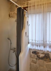 a shower in a bathroom with a window at Petite Olive House in Sitia