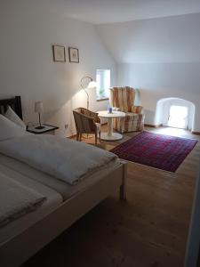 1 dormitorio con 1 cama, mesa y sillas en Gästehaus Hans Moser en Purbach am Neusiedlersee