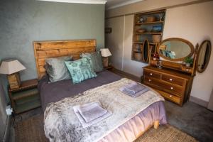 a bedroom with a large bed and a mirror at Clifford Selfcatering Guesthouse in Barkly East