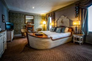 a bedroom with a large bed with a bath tub in it at Dunkeld House Hotel in Dunkeld