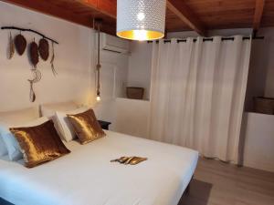 a bedroom with a white bed with gold pillows at Finca Rayo del Sol in Alhaurín el Grande +84 photos