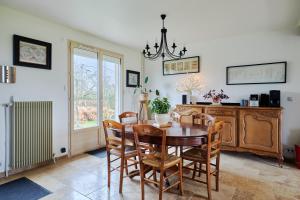 a dining room with a table and chairs at Maison Boisée - Charmante maison au calme in Courbépine