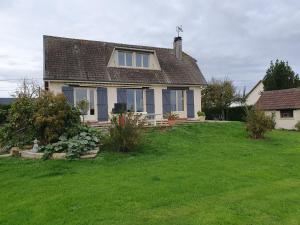 a house with a yard with green grass at Maison Boisée - Charmante maison au calme 