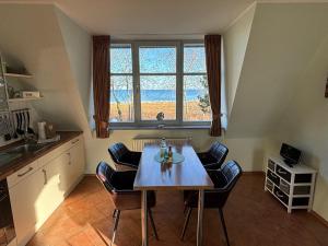 cocina con mesa, sillas y ventana en 2 Zimmer Appartement Ostseeblick, en Boltenhagen