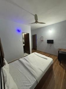 a bedroom with a bed and a ceiling fan at Lotus Guest House in Kharakvasla