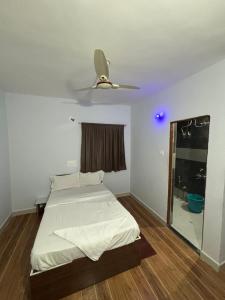 a bedroom with a bed and a ceiling fan at Lotus Guest House in Kharakvasla