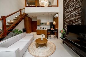 a living room with a white couch and a table at Sunny Cuddles in Canggu