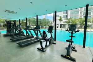 een fitnessruimte met diverse loopbanden en een zwembad bij D'Rapport Residence KL by manatidur in Kuala Lumpur