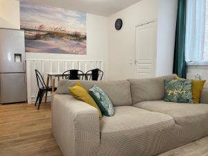 ein Wohnzimmer mit einem Sofa und einem Tisch in der Unterkunft Chambre privée proche de Paris in Ivry-sur-Seine