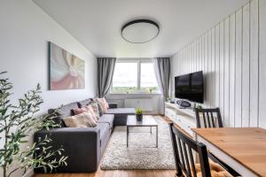 a living room with a couch and a table at Cozy Apartment with panoramic view in Anykščiai