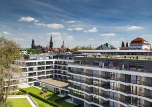 een groot appartementencomplex met een stad op de achtergrond bij Residenz am Zwinger in Dresden