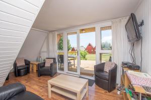 a living room with chairs and a tv and a table at Chalet 137 in Deal