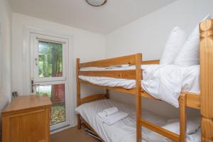 a bedroom with two bunk beds and a window at Chalet 137 in Deal