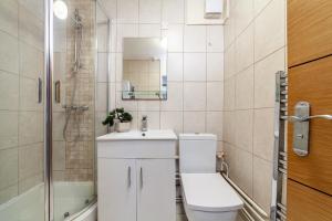 uma casa de banho com um WC, um lavatório e um chuveiro em The Archway Collection em Londres