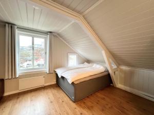 Dormitorio pequeño con cama en el ático en Sentrum - Koselig hus med parkering, en Arendal