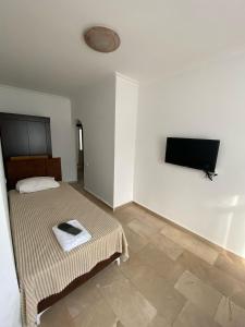 a bedroom with a bed and a flat screen tv at Alanya Central Apartments in Alanya