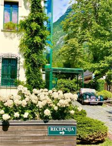 an old car parked in front of a building with flowers at Boutique Hotel Dobra Vila Bovec in Bovec