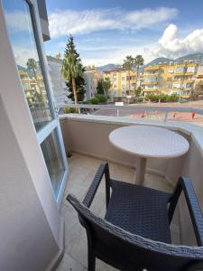balcón con mesa, sillas y vistas a la ciudad en Alanya Central Apartments en Alanya