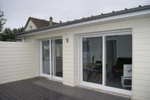 a sliding glass door on the side of a house at Le Tiot Gîte in Le Bois de Cise