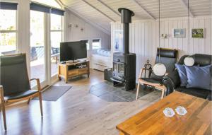 SpodsbjergにあるAmazing Home In Rudkbing With Saunaのリビングルーム(ソファ、薪ストーブ付)