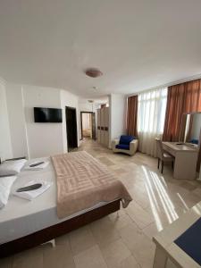 a hotel room with a large bed and a desk at Alanya Central Apartments in Alanya