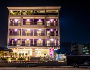 a tall building with purple lights on it at Regenta Central Puri Odisha in Puri
