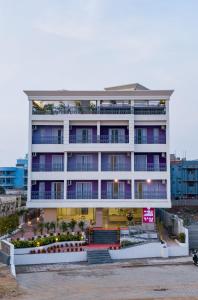 a large white building with purple windows at Regenta Central Puri Odisha in Puri