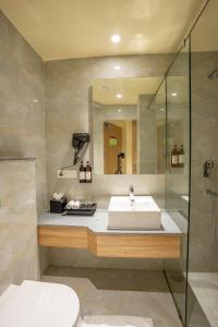a bathroom with a sink and a shower at Regenta Central Puri Odisha in Puri