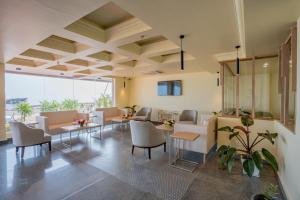 a living room with tables and chairs and windows at Regenta Central Puri Odisha in Puri