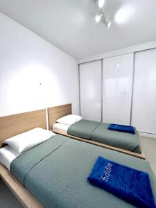 two beds in a room with a blue pillow at Blissapartments T2 - Simone (nearby the beach) in Mindelo