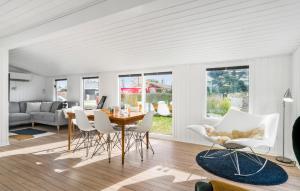 uma sala de estar com uma mesa e cadeiras brancas em 3 Bedroom Beautiful Home In Juelsminde em Juelsminde