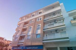 Stayhere Rabat - Hassan - Authentic Residence في الرباط: مبنى طويل وبه شرفات على جانبه