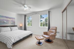 a bedroom with a bed and a chair at Hobart City Townhouse in Hobart