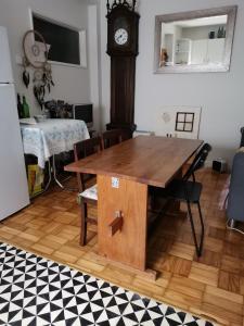 une table en bois et une horloge dans la chambre dans l'établissement Alex Point - Guest House, à Viana do Castelo
