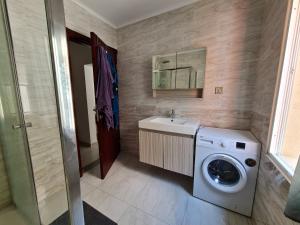 uma casa de banho com uma máquina de lavar roupa e um lavatório em Lovely 1-Bed Apartment in Luanda em Luanda