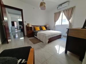 Lovely 1-Bed Apartment in Luanda في لواندا: غرفة نوم بسرير مع مخدات صفراء
