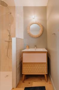 een badkamer met een wastafel, een spiegel en een douche bij Maison face à la mer dans un domaine écologique in Villerville