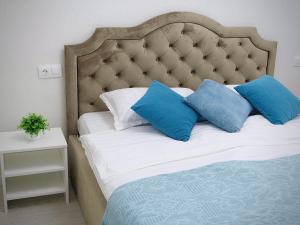 un letto con cuscini bianchi e blu di Only Sun a Astana