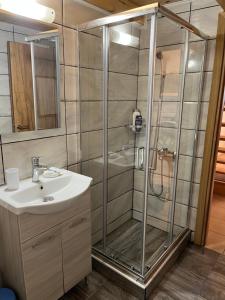 a shower with a glass door next to a sink at Irene’s house in Koskinou